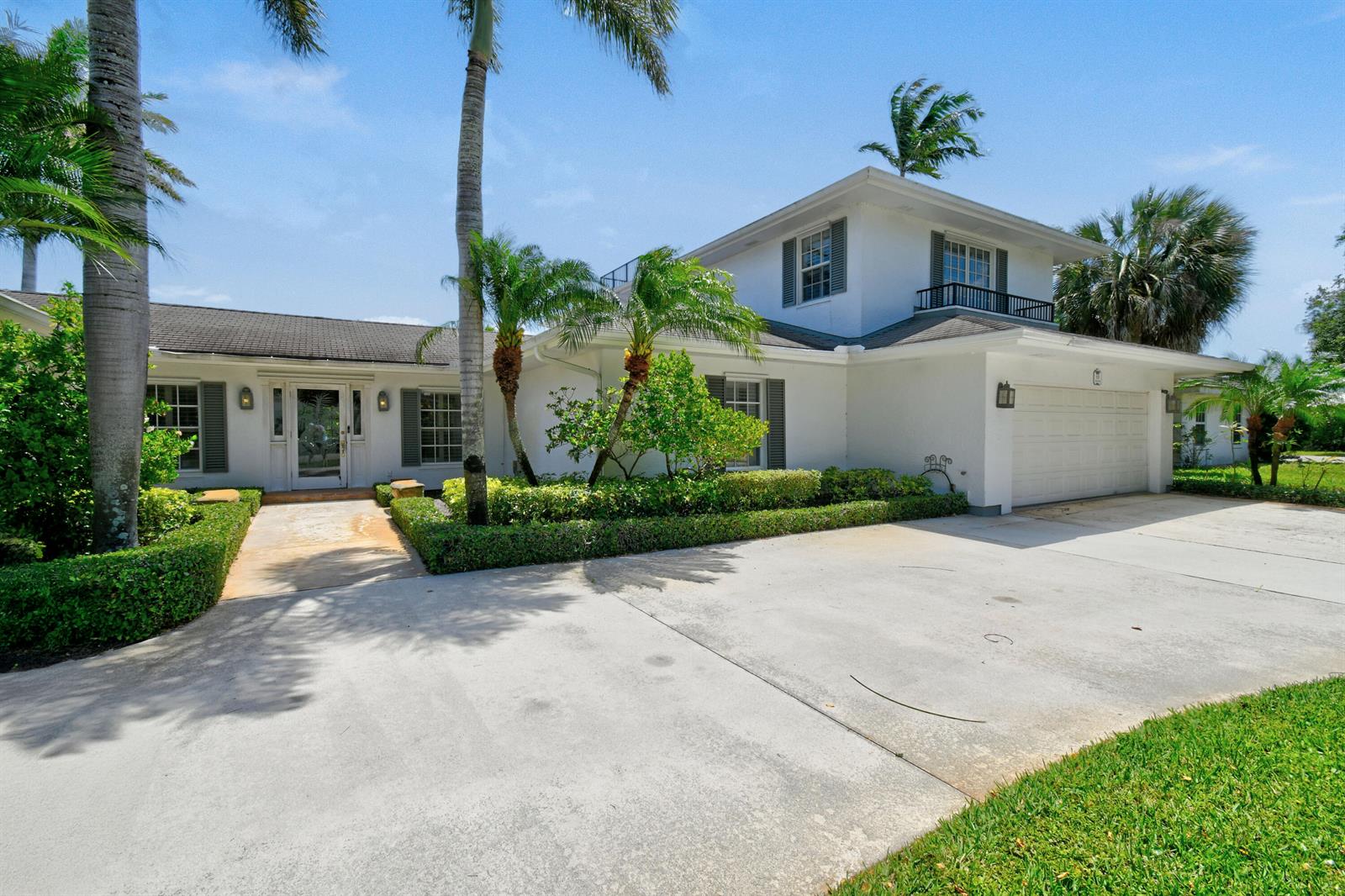 A two-story white house features a concrete driveway, palm trees, and a two-car garage — 938 Turner Quay, Jupiter FL 33458, JUPITER, FL