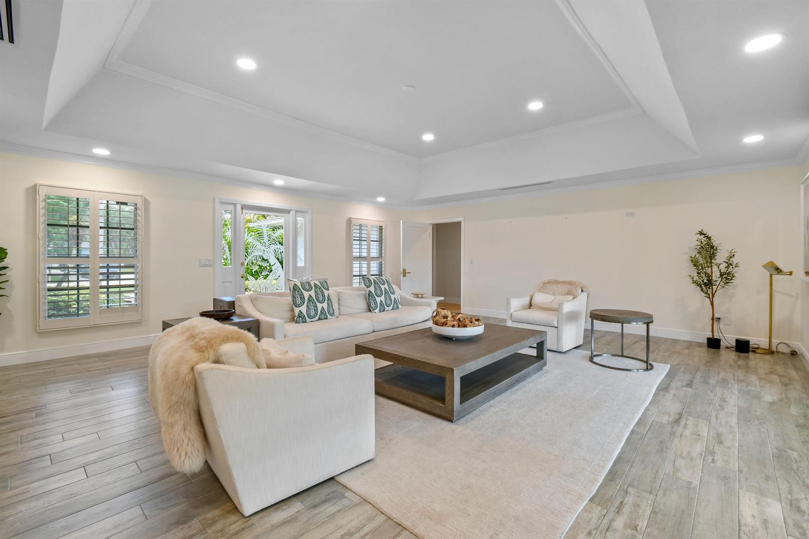 A living room features a tray ceiling, light-colored furniture, a wooden coffee table, and tile flooring — 938 Turner Quay, Jupiter FL 33458, JUPITER, FL