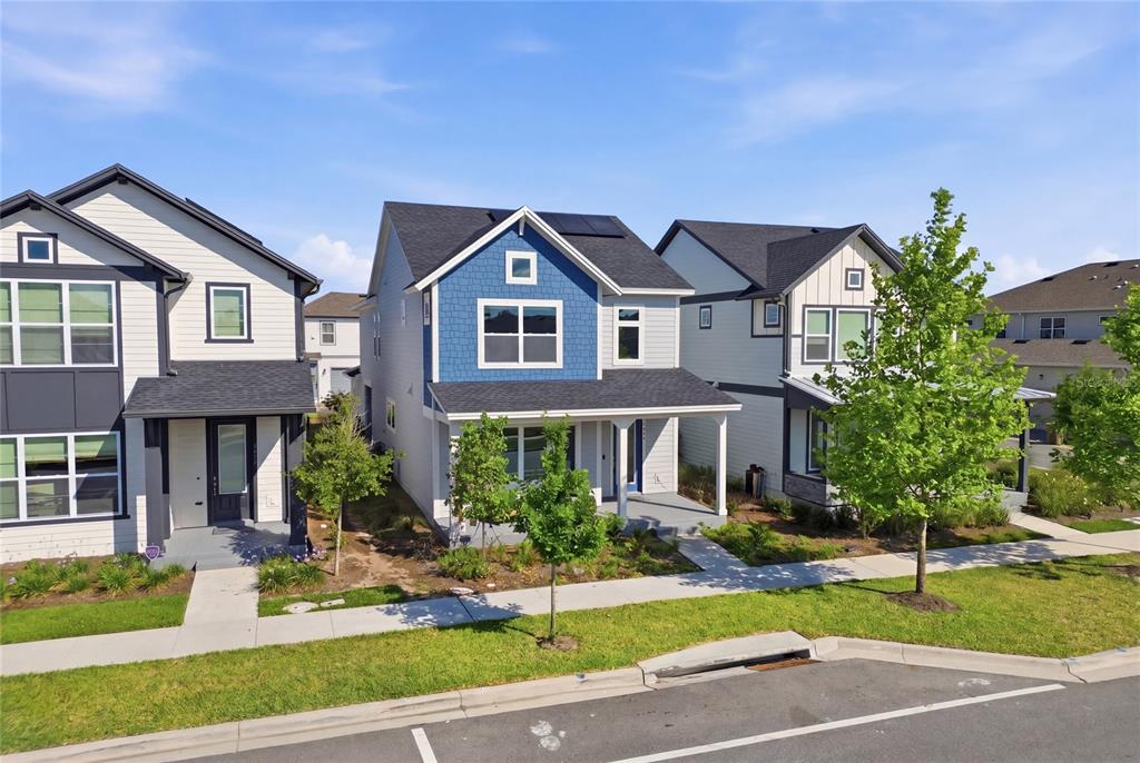 Three modern two-story suburban houses with blue and white siding stand along a paved street — 3007 MIRAGE PLACE, ST CLOUD, FL