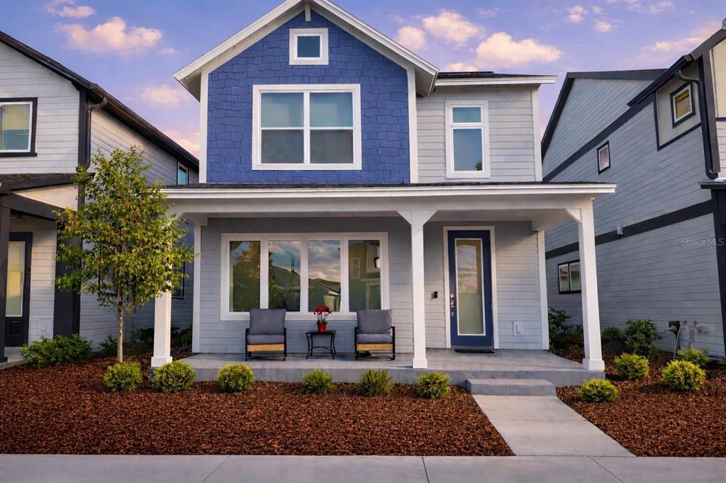 A two-story house with blue shingle siding, a front porch, and a concrete walkway — 3007 MIRAGE PLACE, ST CLOUD, FL