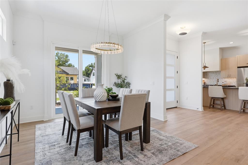A dining room with a wooden table, upholstered chairs, and a chandelier near a kitchen — 1063 SW 135 DRIVE, NEWBERRY, FL