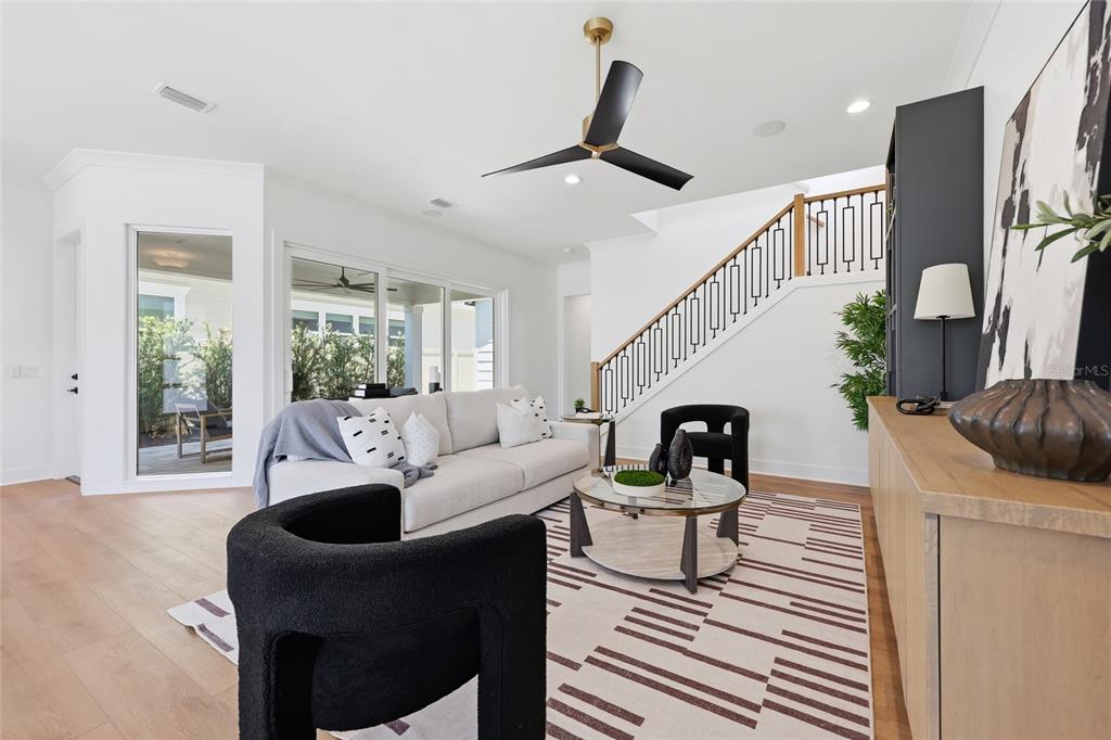 A living room features a white sofa, two black chairs, a coffee table, and stairs — 1063 SW 135 DRIVE, NEWBERRY, FL
