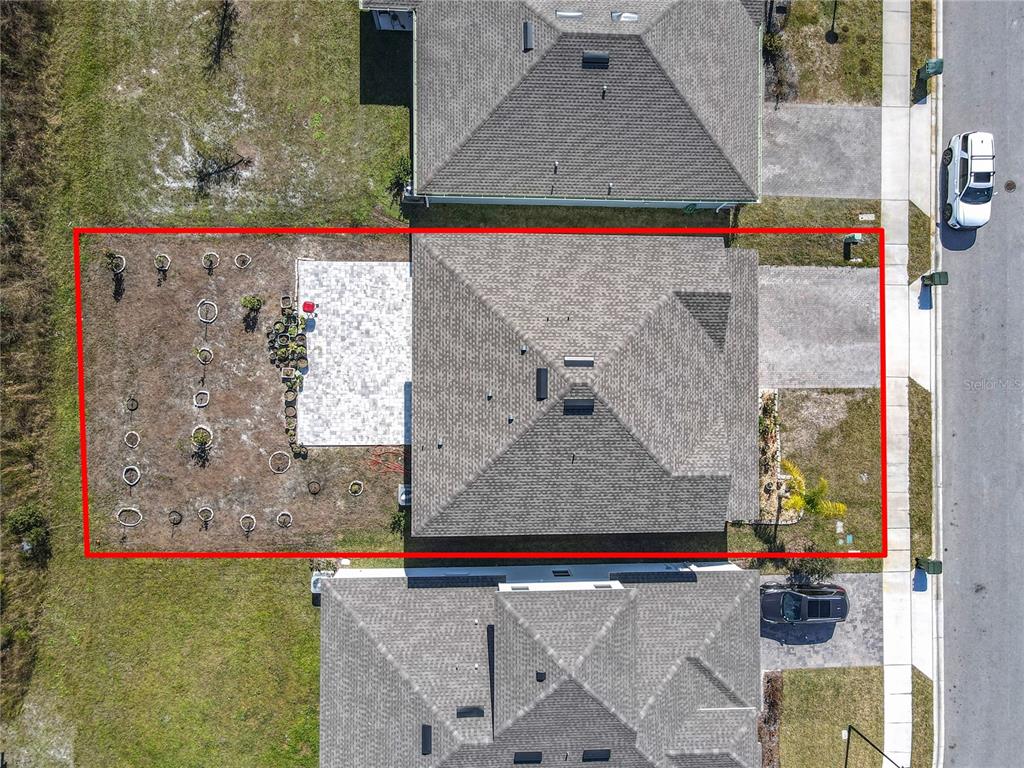An aerial view shows a house with a paved patio and a fenced backyard — 121 EAGLE HARBOR WAY WAY, DAYTONA BEACH, FL