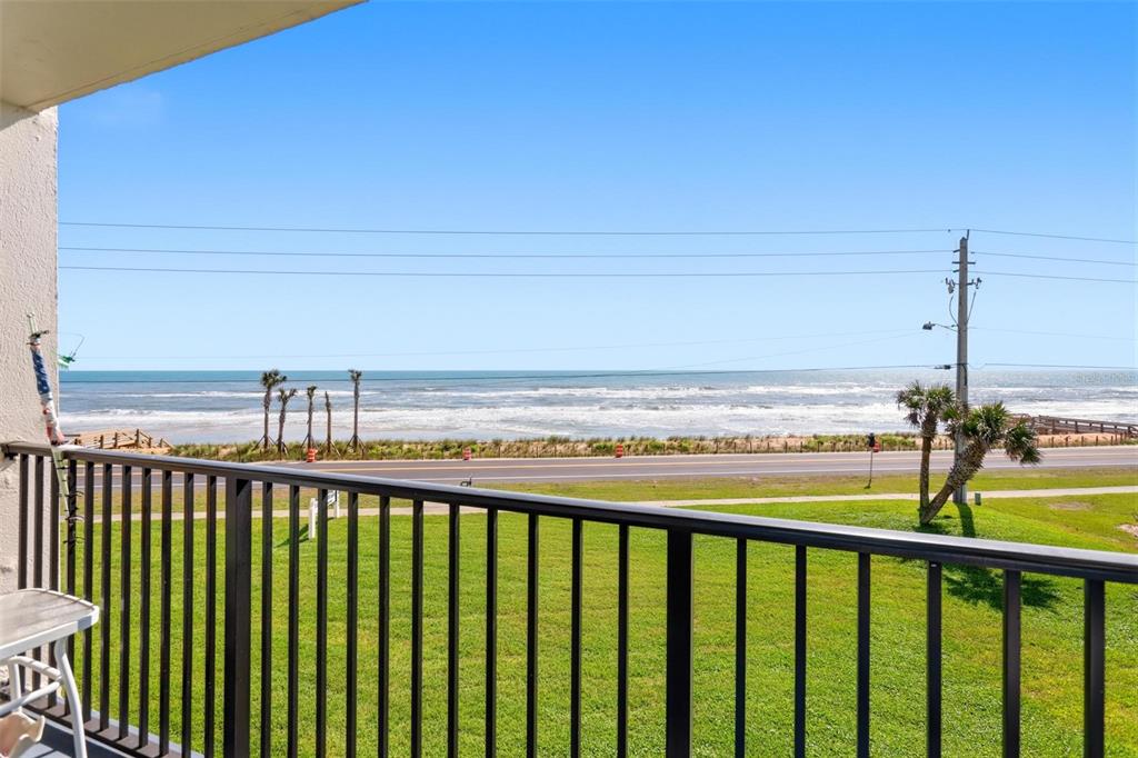 A balcony view overlooking a grassy lawn, a coastal road, and the ocean — 2860 OCEAN SHORE BOULEVARD UNIT 3030, ORMOND BY THE SEA, FL