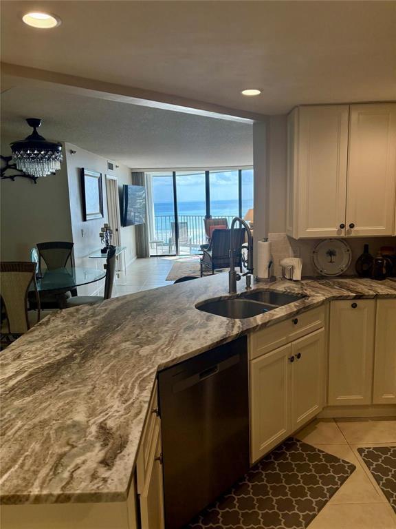 A kitchen with granite countertops and stainless steel appliances overlooks a living area with ocean views — 9650 S Ocean Drive S # 809, Jensen Beach FL 34957, JENSEN BEACH, FL