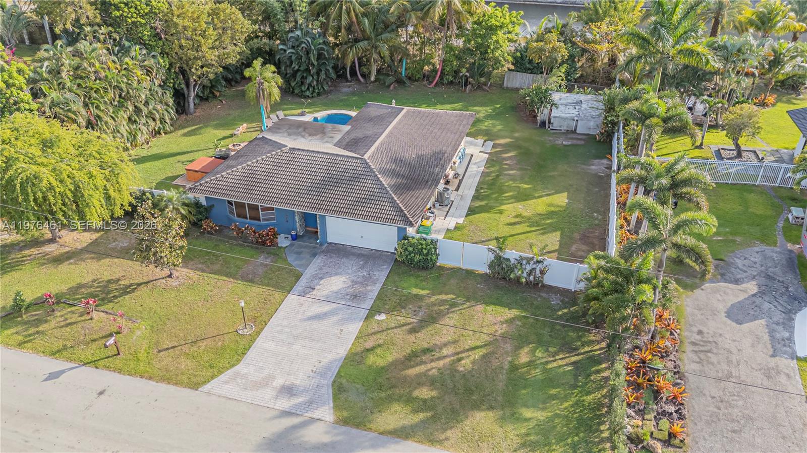 An aerial view shows a blue house with a tiled roof, pool, and large yard — 11400 Tara Dr, Plantation FL 33325, PLANTATION, FL