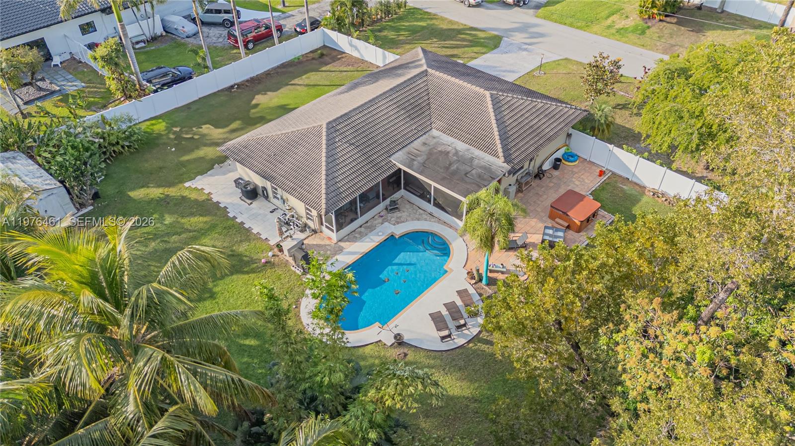 An aerial view of a house with a pool, patio, and fenced backyard — 11400 Tara Dr, Plantation FL 33325, PLANTATION, FL