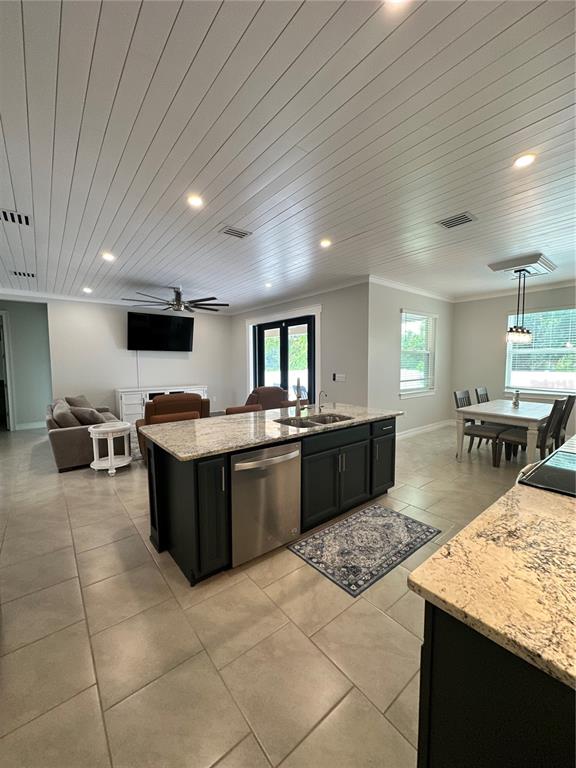 An open-concept kitchen and living area features dark cabinets, granite countertops, and wood-plank ceilings — 1871 BRADDOCK AVENUE, NORTH PORT, FL