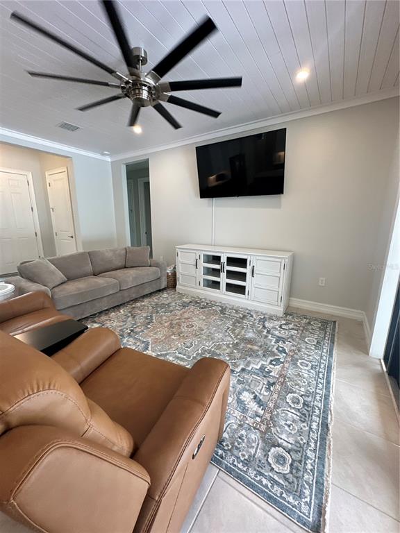 A living room features a grey sofa, brown leather chair, ceiling fan, and television console — 1871 BRADDOCK AVENUE, NORTH PORT, FL
