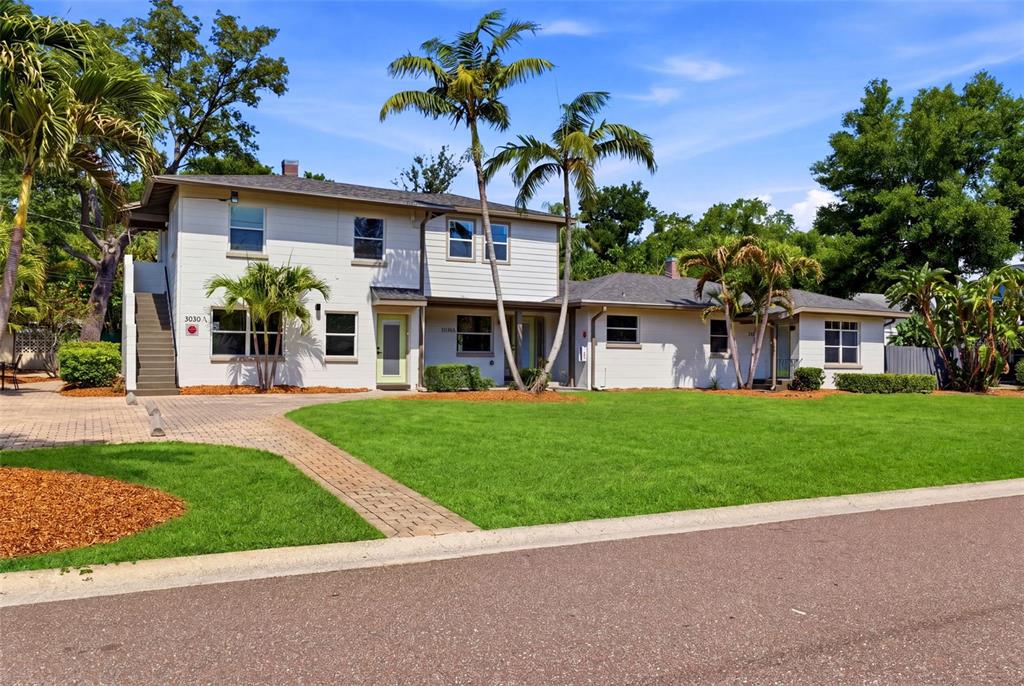 A two-story apartment building with light siding, palm trees, and a green lawn — 3030 5TH STREET N, ST PETERSBURG, FL
