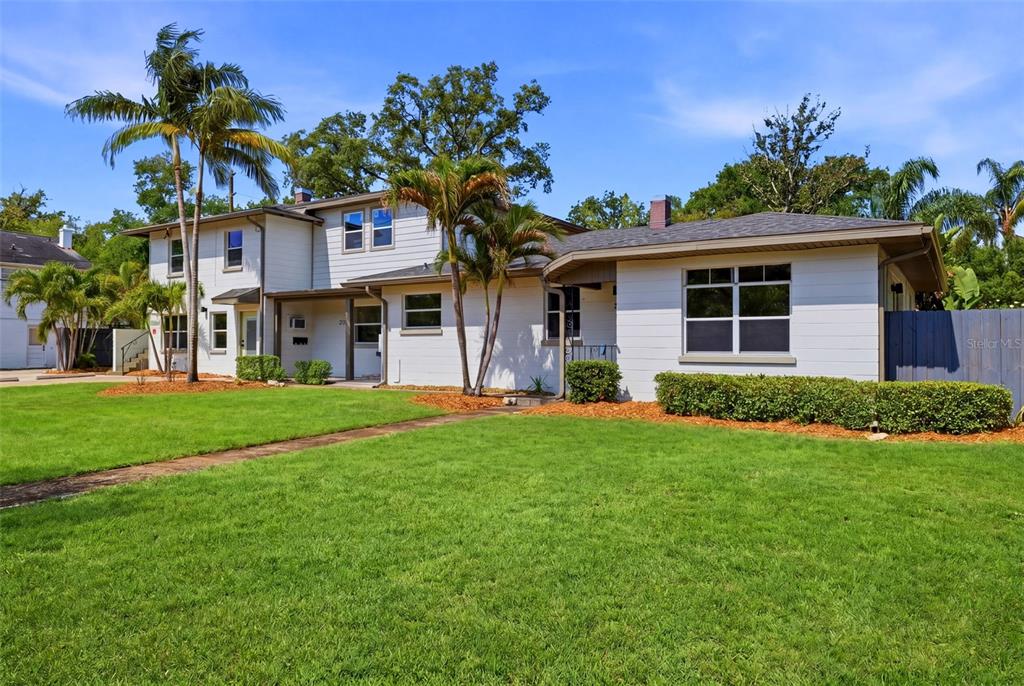 A two-story white house with a lawn, palm trees, and a blue privacy fence — 3030 5TH STREET N, ST PETERSBURG, FL