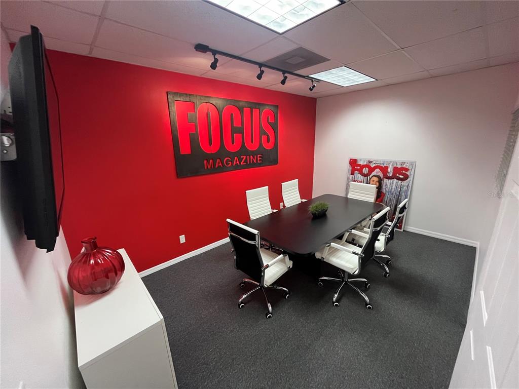 A conference room features a red accent wall with a Focus Magazine sign and chairs — 702 W DR MARTIN LUTHER KING JR BOULEVARD, PLANT CITY, FL