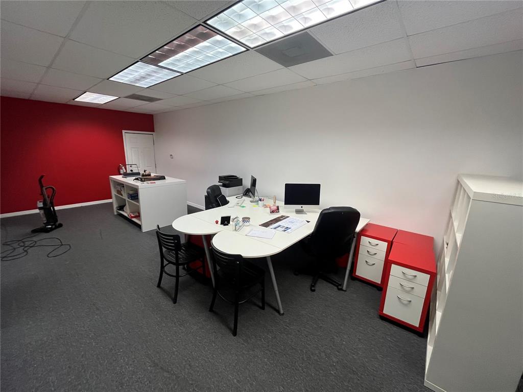 An office space features a white desk, red accent wall, and gray carpeting — 702 W DR MARTIN LUTHER KING JR BOULEVARD, PLANT CITY, FL