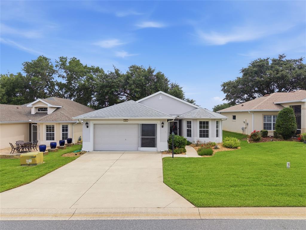 A single-story house with a white garage, a concrete driveway, and a green lawn — 4905 KELSO STREET, LEESBURG, FL