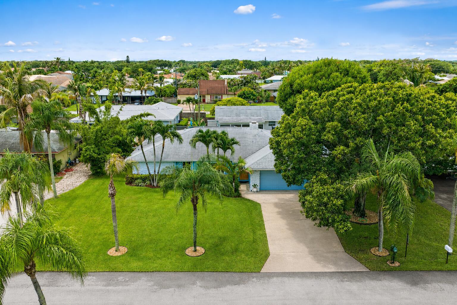 An aerial view of a single-story house with a green lawn and palm trees — 76 Wingo Street, Tequesta FL 33469, TEQUESTA, FL