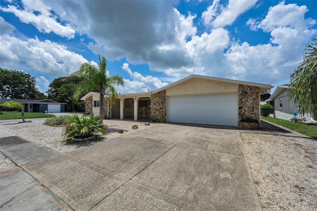 A single-story house with a stone facade, a two-car garage, and a concrete driveway — 5834 EMBAY AVENUE, NEW PORT RICHEY, FL