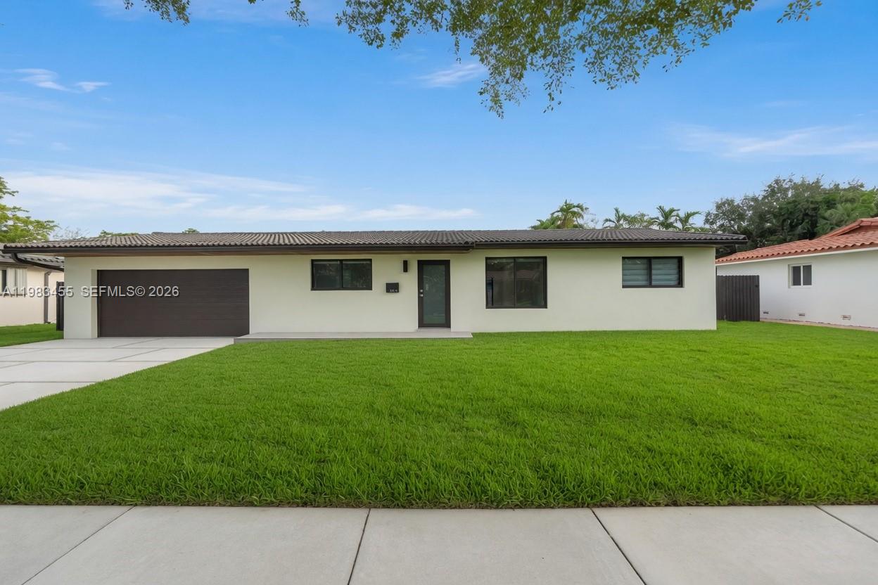 A single-story house with a dark garage door, light-colored exterior walls, and a green lawn — 14515 Mahogany Ct, Miami Lakes FL 33014, MIAMI LAKES, FL