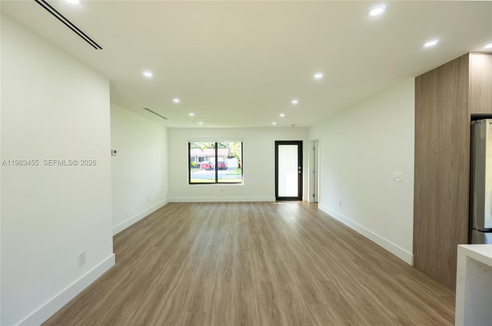 This empty room features light wood-look flooring, recessed ceiling lights, and a single window — 14515 Mahogany Ct, Miami Lakes FL 33014, MIAMI LAKES, FL