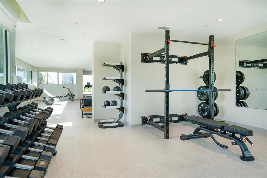 A home gym features a weight rack, a bench, a dumbbell rack, and a rowing machine — 900 N OSCEOLA AVENUE UNIT 401, CLEARWATER, FL