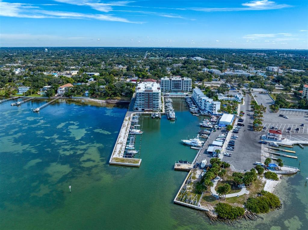 An aerial view of a marina with docked boats, a large apartment building, and parking — 900 N OSCEOLA AVENUE UNIT 401, CLEARWATER, FL