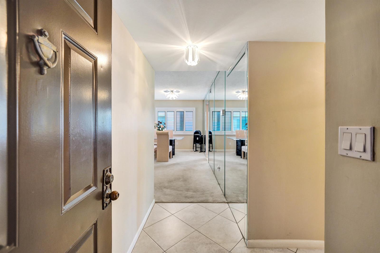 An entryway with tile flooring leads into a carpeted living area featuring mirrored walls — 2160 SW 93 Way # 1002, Davie FL 33324, DAVIE, FL