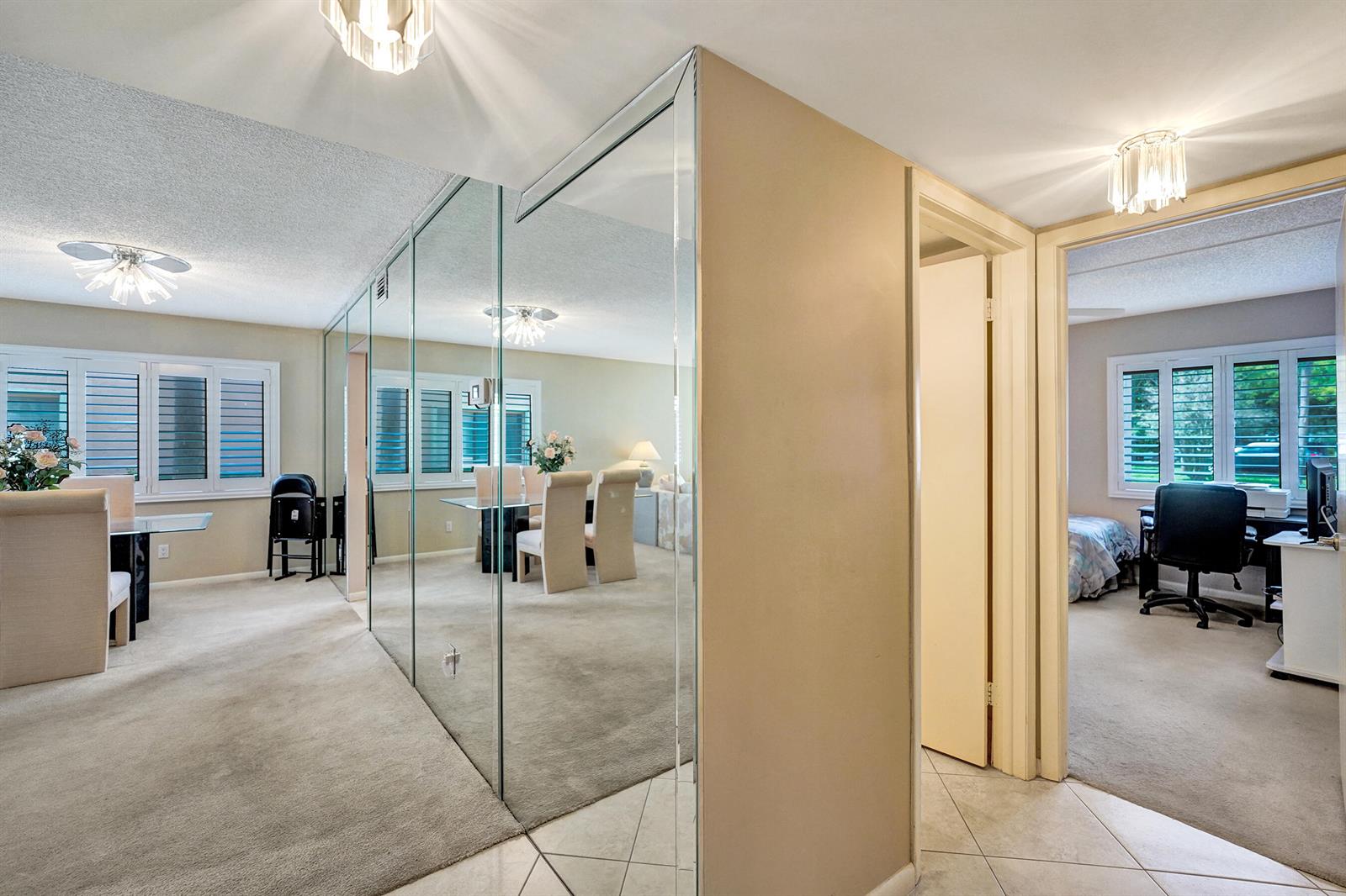 A dining area with mirrored walls and carpeted floors sits next to a bedroom doorway — 2160 SW 93 Way # 1002, Davie FL 33324, DAVIE, FL