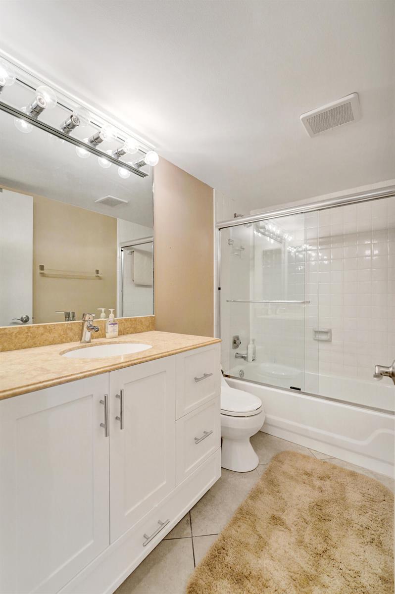A bathroom features a white vanity with a tan countertop, a mirror, and a tub-shower — 2160 SW 93 Way # 1002, Davie FL 33324, DAVIE, FL