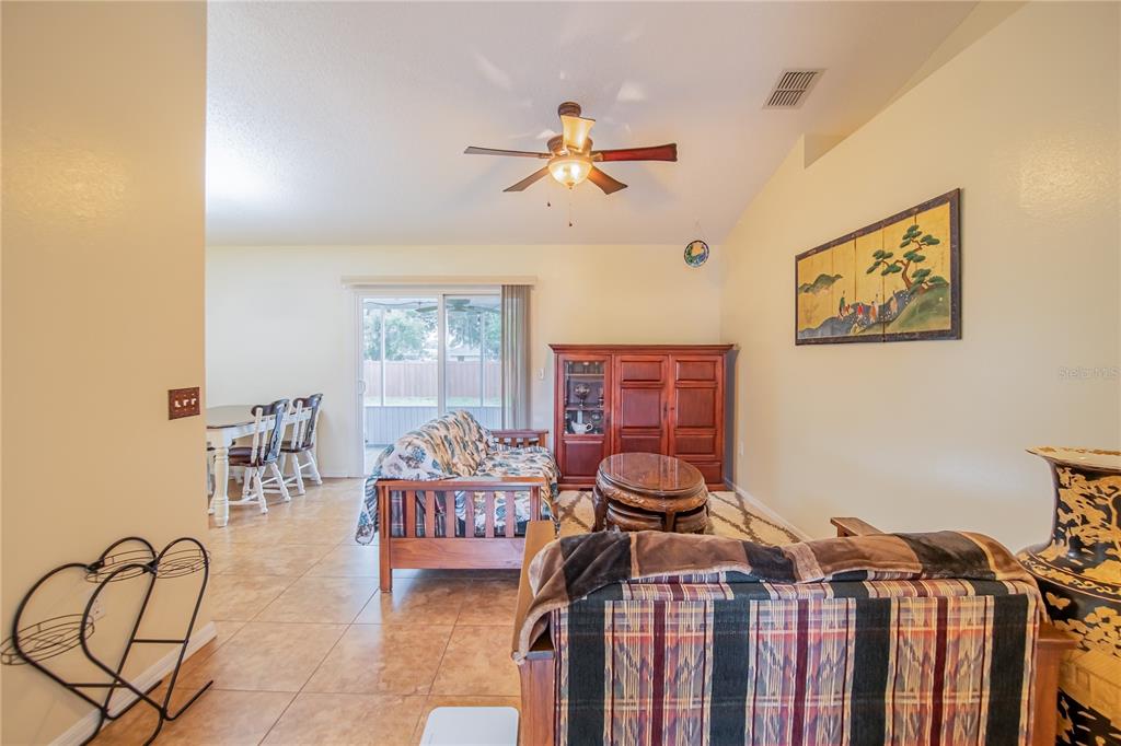 A kitchen features wood cabinets, white appliances, a double sink, and light-colored countertops — 7160 PEBBLE PASS LOOP, LAKELAND, FL