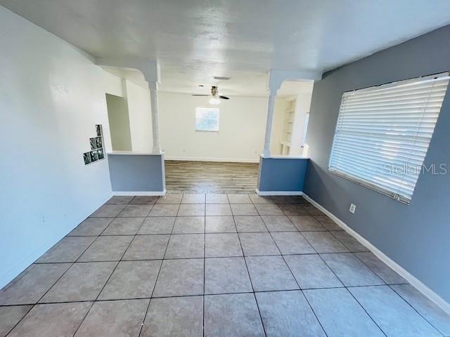 A room with tiled flooring features a partial wall with columns opening into another space — 4428 CAROUSEL ROAD, ORLANDO, FL