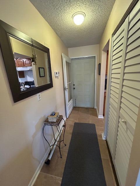 A hallway features a mirror, a small accent table, a runner rug, and louvered closet doors — 1951 SW Palm City Road # H, Stuart FL 34994, STUART, FL