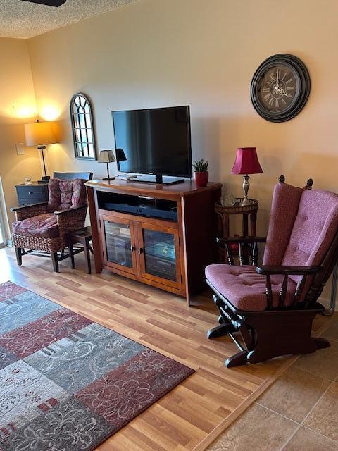 A living room features a television on a wooden stand, two chairs, and a clock — 1951 SW Palm City Road # H, Stuart FL 34994, STUART, FL
