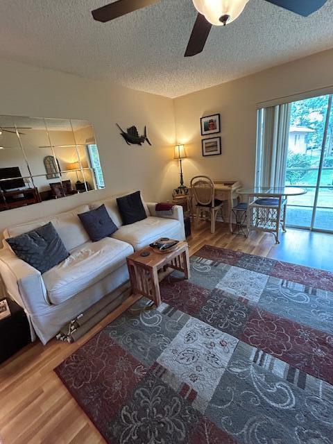 A living room features a white sofa, a patterned area rug, and a dining nook — 1951 SW Palm City Road # H, Stuart FL 34994, STUART, FL