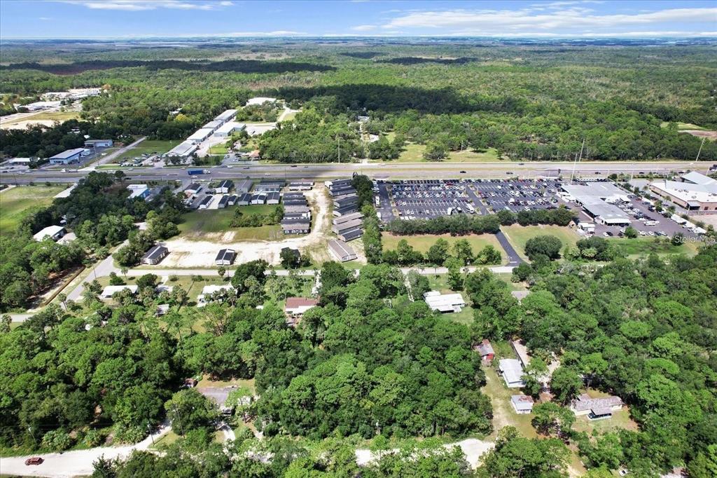 An aerial view shows a residential area with mobile homes, a parking lot, and surrounding woods — 1420 S HIGHCLIFF POINT, HOMOSASSA, FL
