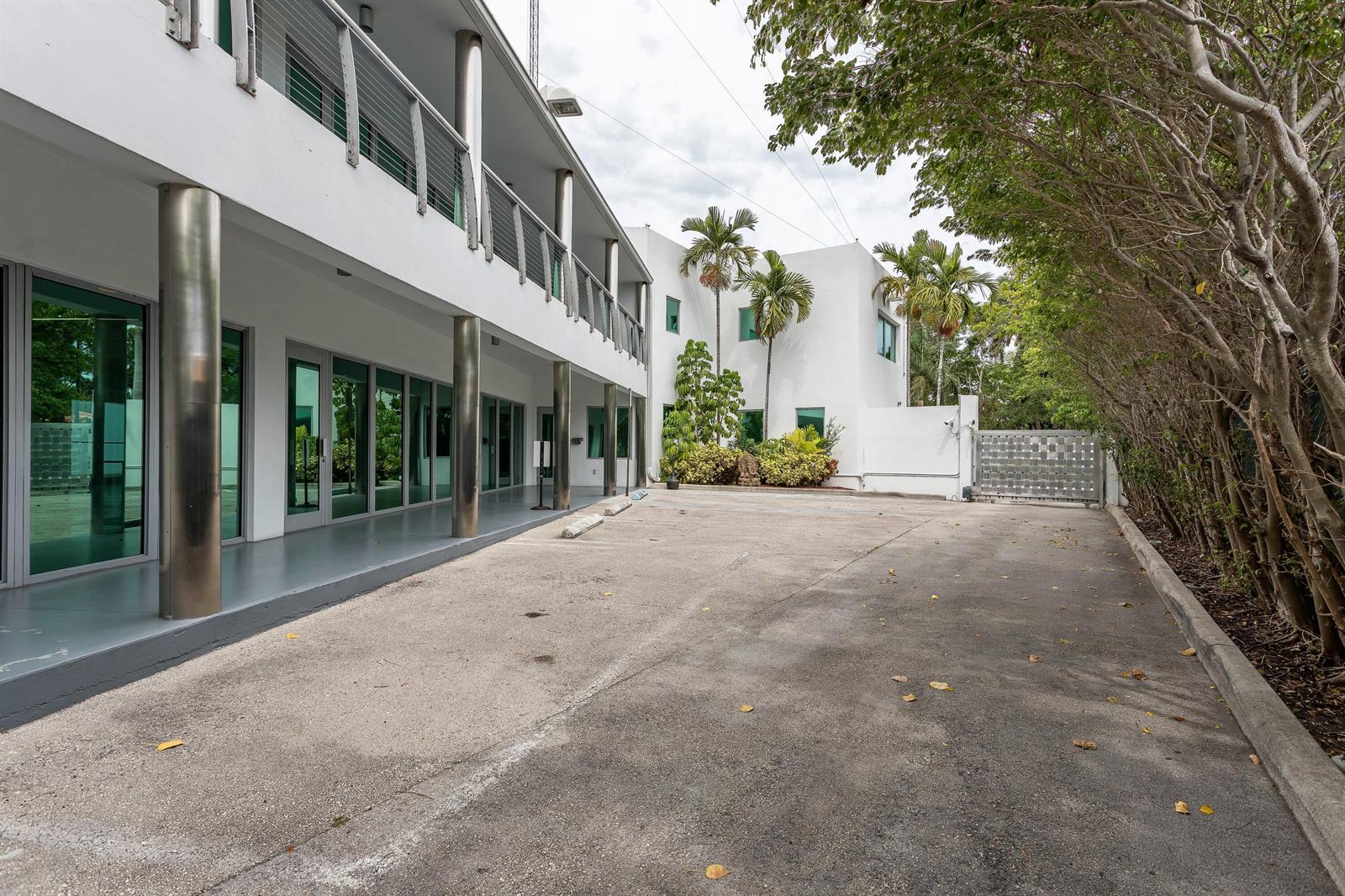 A two-story white modern building with a concrete parking area and metal support columns — 5020 Biscayne Boulevard, Miami FL 33137, MIAMI, FL