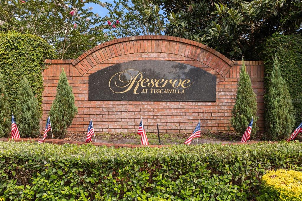 A brick monument sign for The Reserve at Tuscawilla sits behind a manicured hedge — 149 CHERRY CREEK CIRCLE, WINTER SPRINGS, FL
