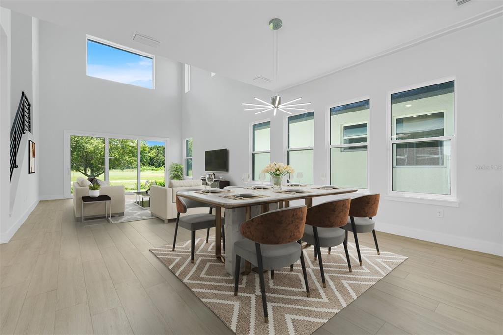 A bright dining room features a modern chandelier, a marble table, and large windows — 3036 KENSINGTON AVENUE, DAVENPORT, FL