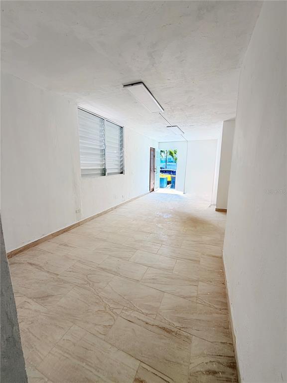 An empty room features light-colored tile flooring, white walls, and a window with louvered blinds — Calle 601 BLOQUE 224 COMERCIAL 1, CAROLINA, PR