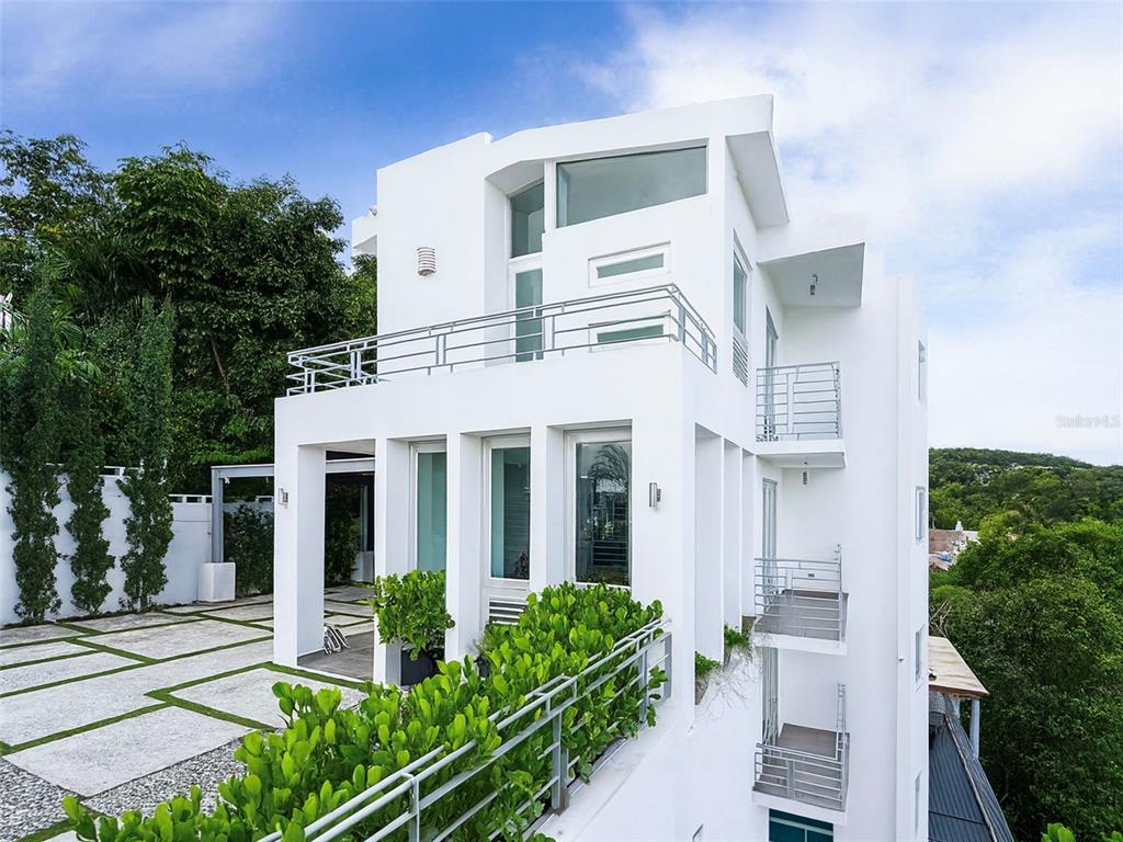 A modern white multi-story house features multiple balconies, large windows, and a paved driveway — SR-830 Int LA FLORESTA SECTOR Lot 3, BAYAMON, PR