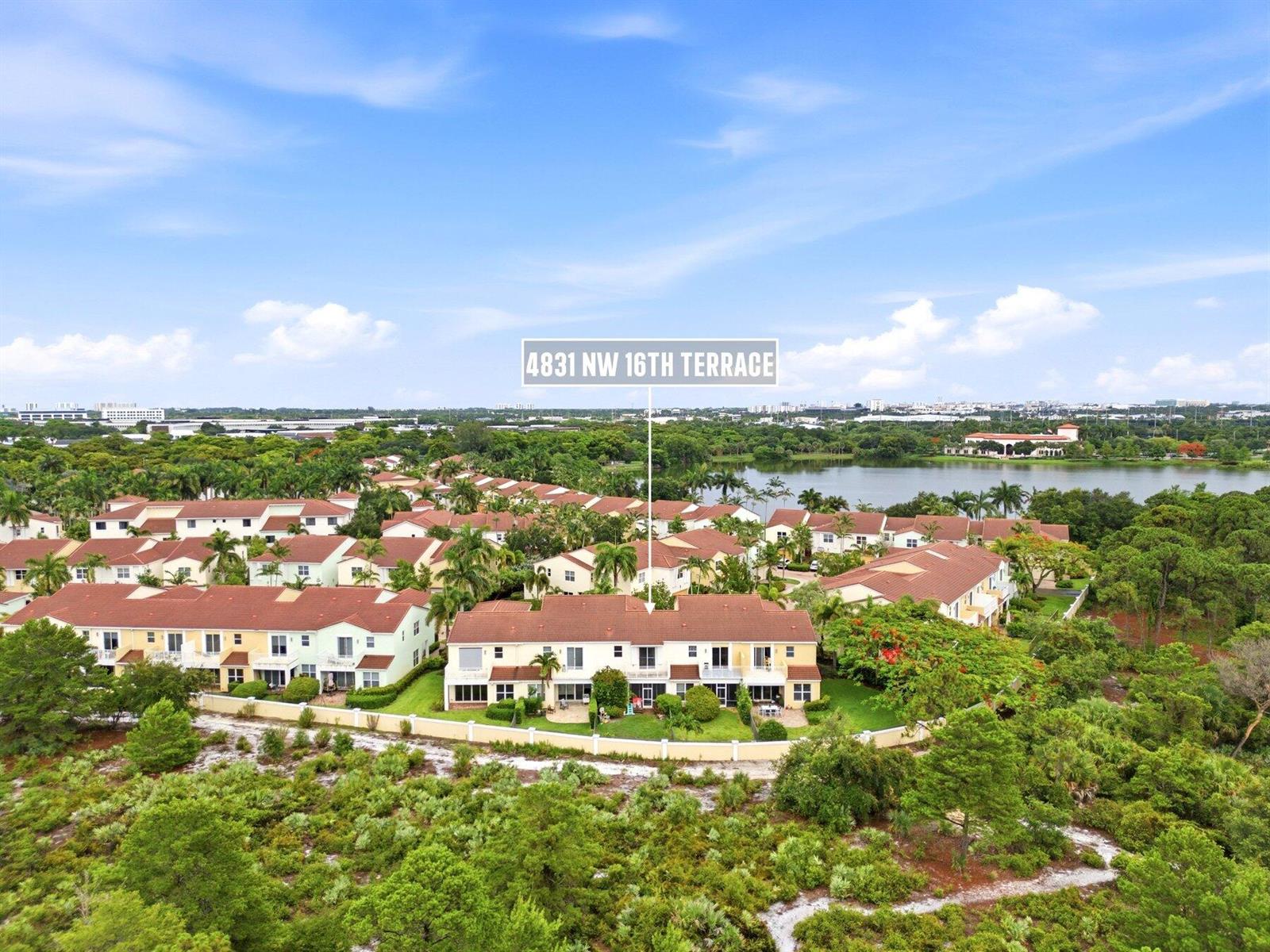 An aerial view shows a multi-unit residential building with red tile roofs near a lake — 4831 NW 16th Terrace, Boca Raton FL 33431, BOCA RATON, FL
