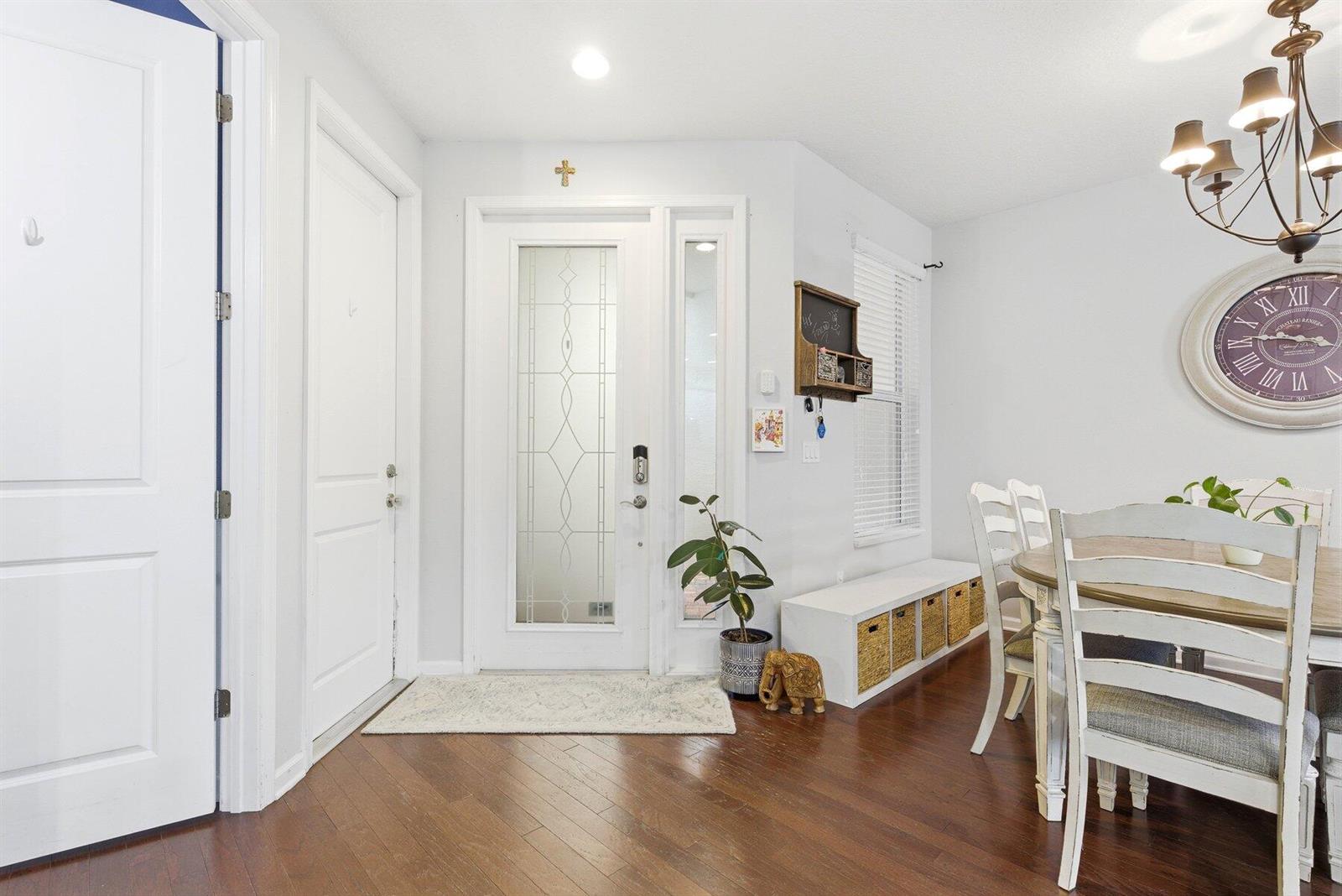 A dining area and entryway feature white doors, hardwood floors, and a decorative wall clock — 4831 NW 16th Terrace, Boca Raton FL 33431, BOCA RATON, FL