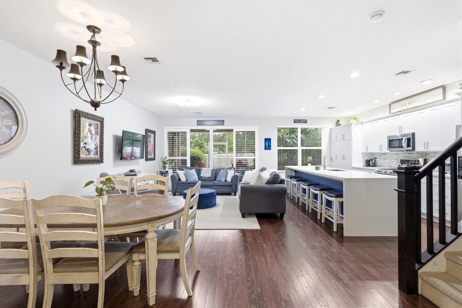 An open-concept living area features a dining set, a blue sofa, and a kitchen island — 4831 NW 16th Terrace, Boca Raton FL 33431, BOCA RATON, FL