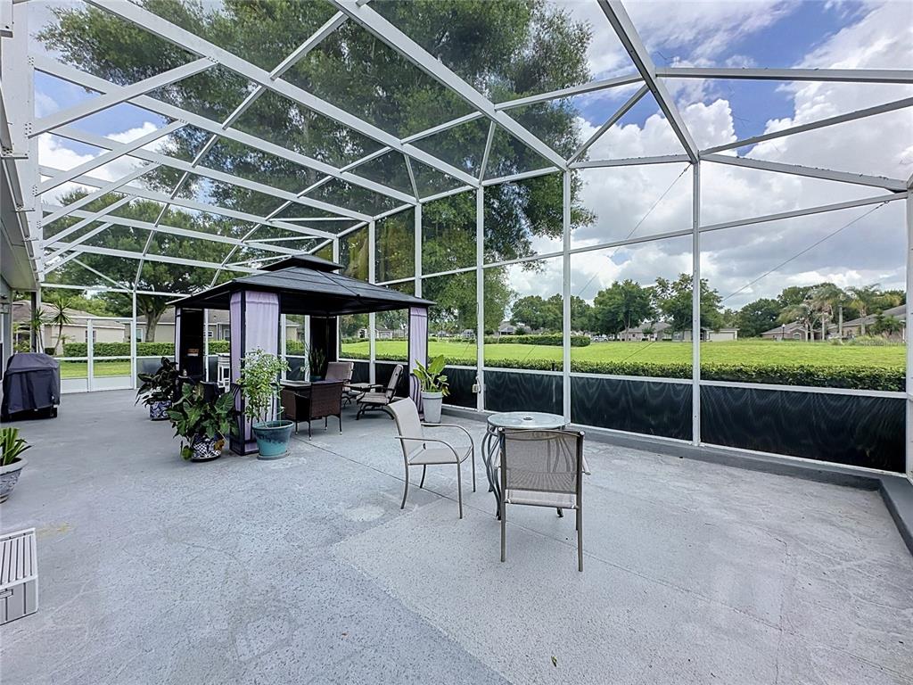 A screened-in patio features a gazebo, outdoor furniture, and a concrete floor — 2265 CALVERT COURT, CLERMONT, FL
