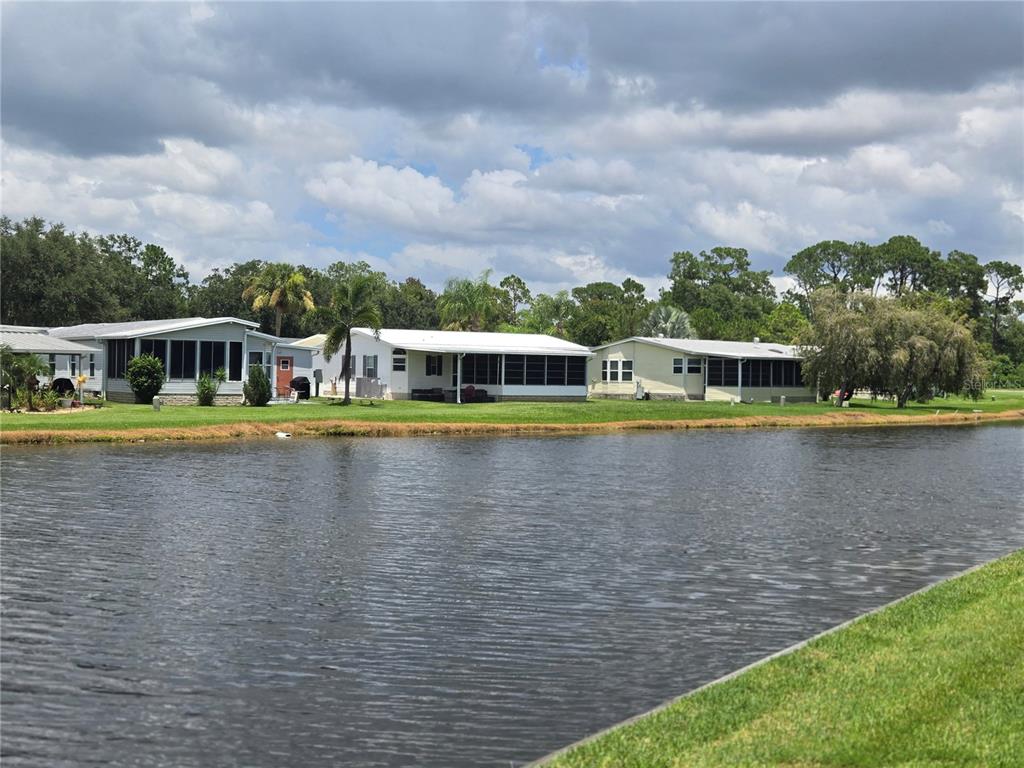 A row of manufactured homes sits along the edge of a small lake — 88 STRAPHMORE DRIVE, HAINES CITY, FL
