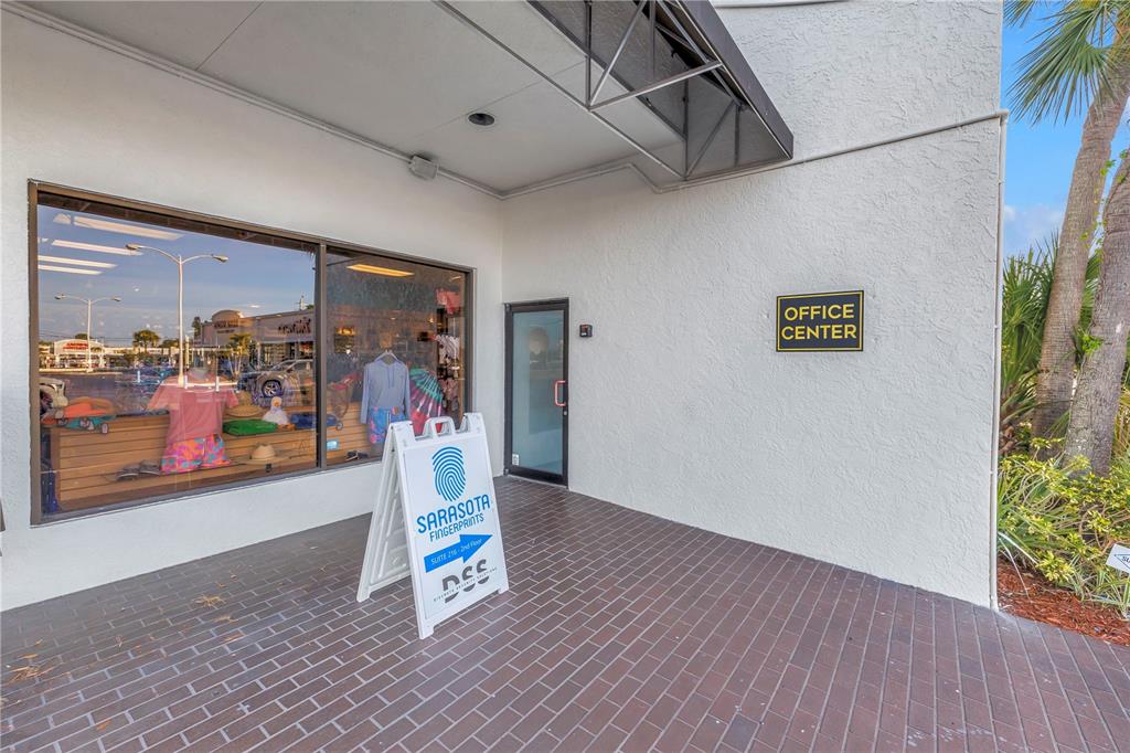 An exterior view of an office building entrance with a glass door and sidewalk sign — 1960 STICKNEY POINT ROAD UNIT 217, SARASOTA, FL