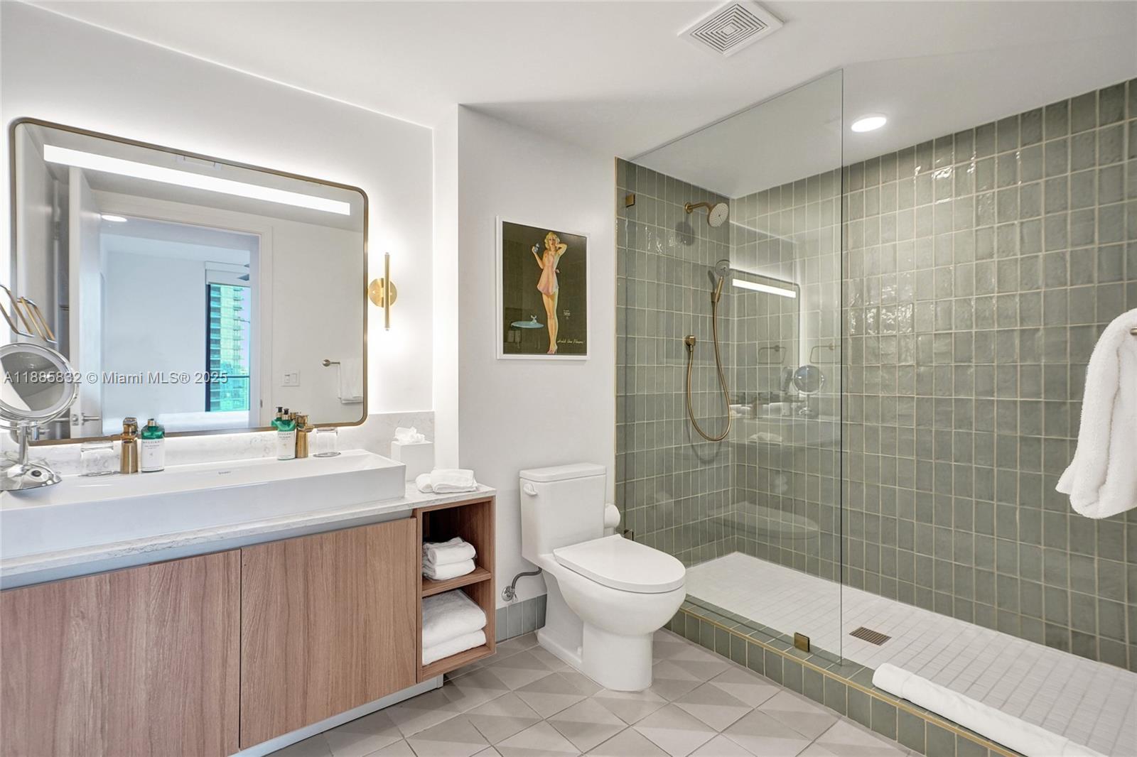 A high-rise balcony features two chairs overlooking a neighboring building and a bay view — 159 NE 6th St # 3302, Miami FL 33132, MIAMI, FL