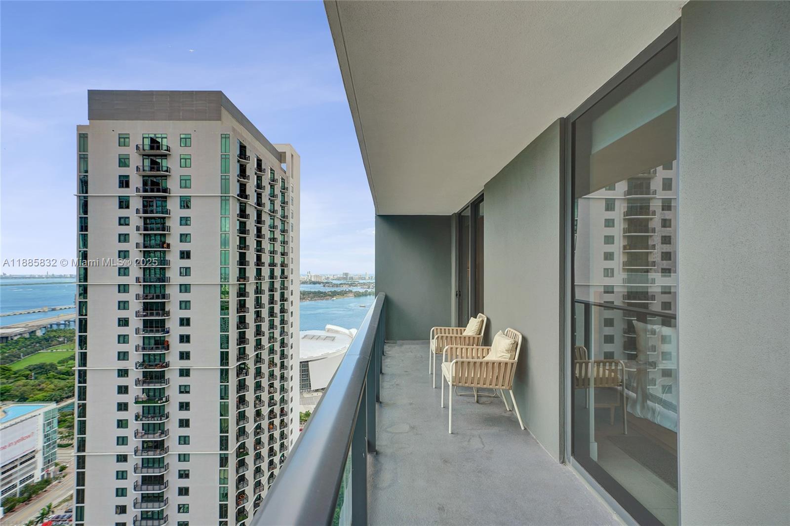 An open-concept living and dining area features a modern kitchen, balcony, and city views — 159 NE 6th St # 3302, Miami FL 33132, MIAMI, FL
