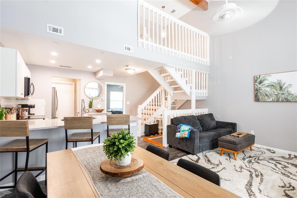An open-concept living area features a kitchen, dining table, and a loft with white railings — 2643 ST JOSEPHS DRIVE W, DUNEDIN, FL