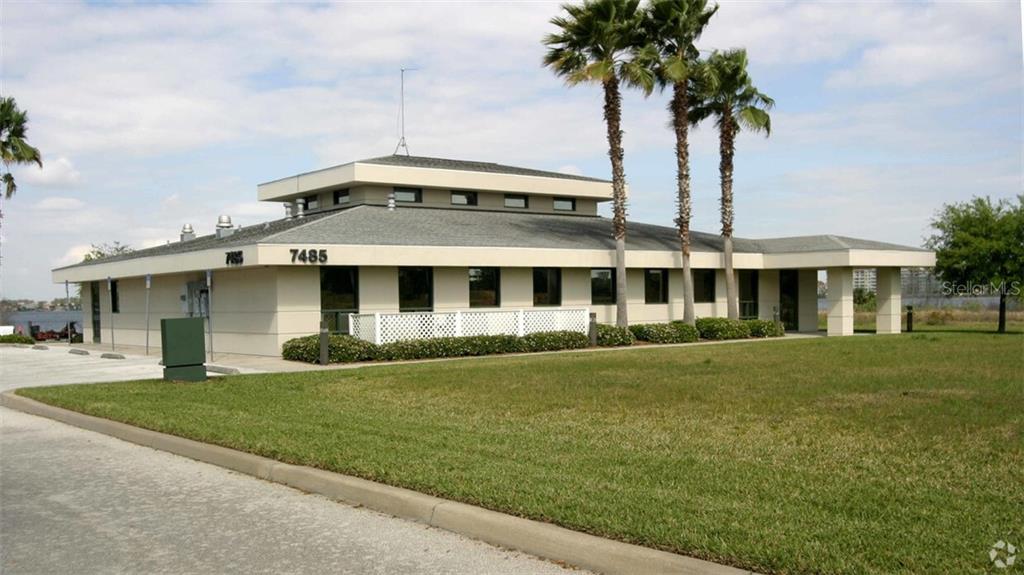 A single-story commercial building with a tiered roof and palm trees on a grassy lot — 7485 SANDLAKE COMMONS BOULEVARD, ORLANDO, FL