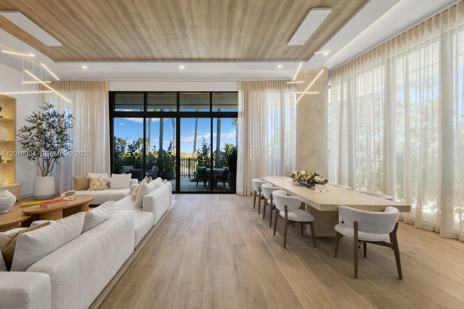 A modern living and dining room features light wood flooring, floor-to-ceiling windows, and contemporary furniture — 900 N Ocean Blvd # 101, Pompano Beach FL 33062, POMPANO BEACH, FL