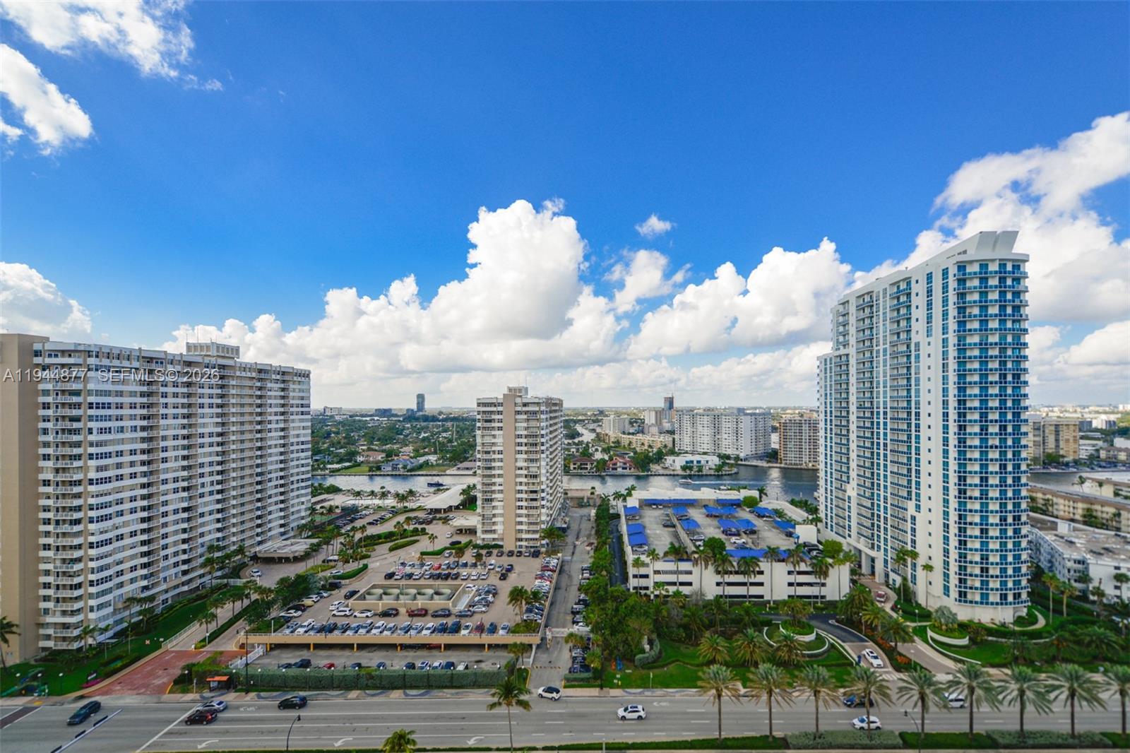 An elevated view shows multiple high-rise apartment buildings, a parking structure, and a waterway — 1950 S Ocean Dr # 19E, Hallandale Beach FL 33009, HALLANDALE BEACH, FL